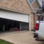 a half open garage door that is broken on one side